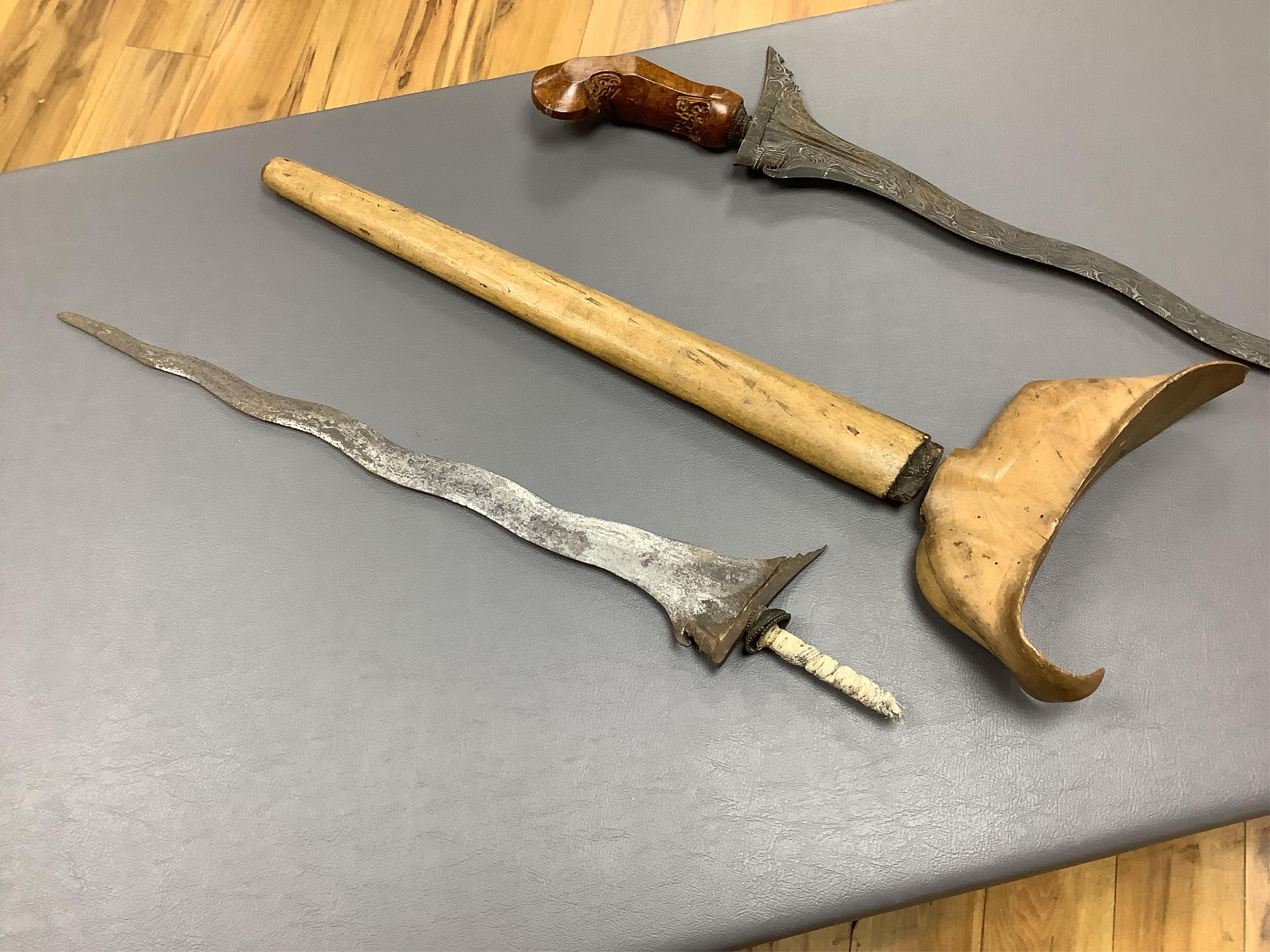 Eighteen assorted world weapons comprising a silver jambya (pommel missing), a knobkerry, a dha, two kris (one with handle missing), a lohar, three kukris, a djambok, a Chinese trousse, a chora, a flyssa, five others and